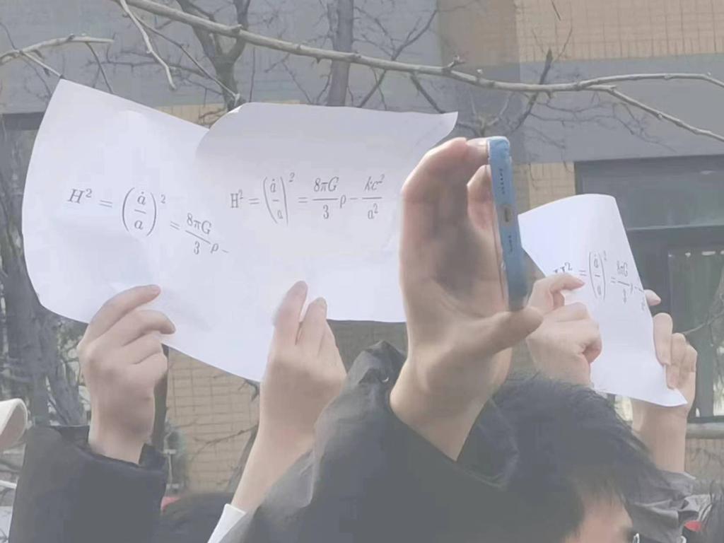 Students from Tsinghua University hold up the Friedman equations.