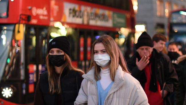 Shoppers, some wearing masks because of the coronavirus pandemic, walk along Regent Street in the main high-street shopping area of London on December 15, 2020 ahead of fresh measures for the capital amid rising infection rates. - The British capital faces tougher Covid-19 measures within days, the UK government said on December 14, with a new coronavirus variant emerging as a possible cause for rapidly rising infection rates. (Photo by DANIEL LEAL-OLIVAS / AFP)