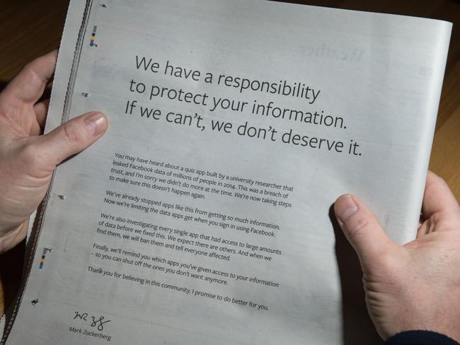 A man reads a full-page advertisment, taken out by Mark Zuckerberg to apologise for the large-scale leak of personal data from the social network. Picture: AFP