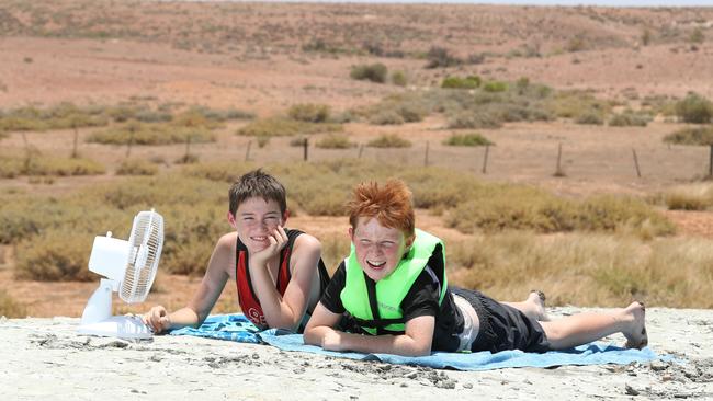 Jake Penhall and William Franklin try in vain to keep cool at Blue Dam, on the outskirts of Andamooka. Picture: TAIT SCHMAAL