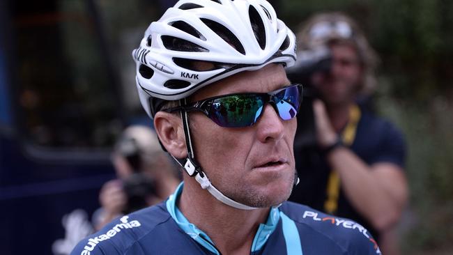 US cyclist Lance Armstrong gets ready in Rodez, southwest France, prior to ride a stage of The Tour De France for a leukaemia charity, a day ahead of the competing riders, on July 17, 2015. For the first time since he was stripped of his seven Tour de France titles, Armstrong rode a stage of the famous race for charity. The charity, the brainchild of former England football international Geoff Thomas who beat leukaemia, aims to raise "around £1 million" (1.4 million euros, $1.5m) mainly via sponsorship garnered by the 10 other amateur cyclists riding the route. AFP PHOTO / STEPHANE DE SAKUTIN