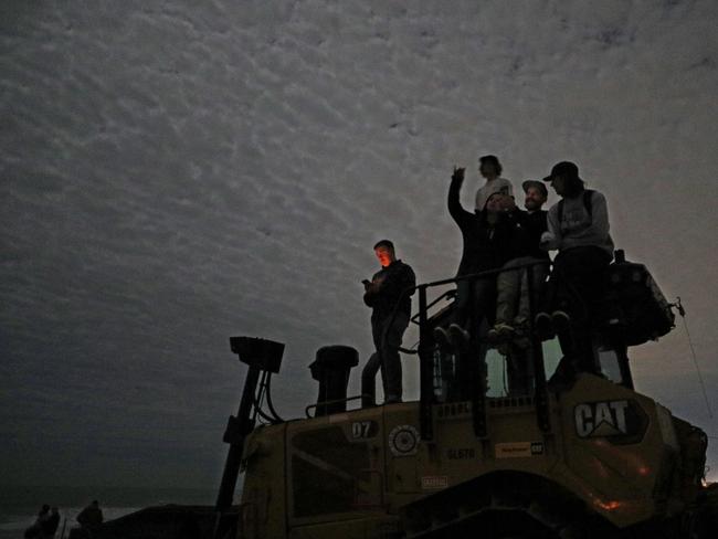 Space enthusiasts at Cocoa Beach perch atop a tractor to watch the maiden flight of the Blue Origin New Glenn rocket. Picture: AFP