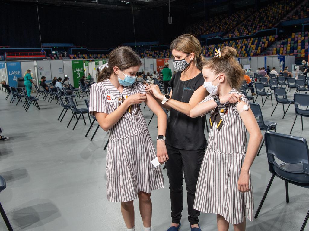 Teen sisters receiving their first Pfizer jabs in Brisbane. Picture: Brad Fleet