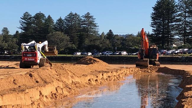 An excavator works to create a channel from Narrabeen Lagoon to the ocean ahead of an expected east coast low to affect the northern beaches. Picture: Jim O'Rourke