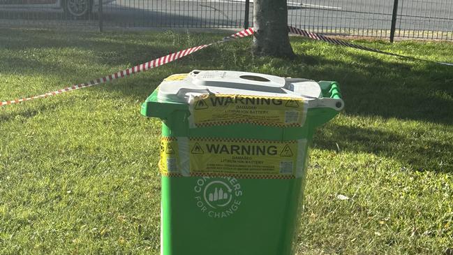 Following a dramatic caravan fire on the Gold Coast last week, an untouched rubbish bin has been cordoned off just metres from the scene, warning of a lithium battery hazard. Picture: Ryan Keen