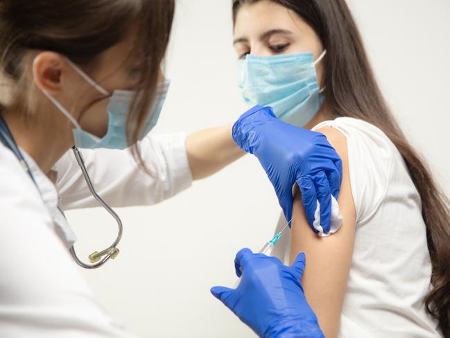 Protect. Close up doctor or nurse giving vaccine to patient using the syringe injected. Works in face mask. Protection against coronavirus, COVID-19 pandemic and pneumonia. Healthcare, medicine.