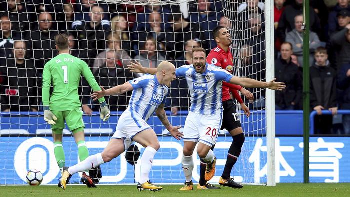 Huddersfield Town's Aaron Mooy, center, celebrates scoring his side's first goal of the game during the English Premier League soccer match between Huddersfield Town and Manchester United at the John Smithâ€™s stadium in Huddersfield, England. Saturday, Oct. 21, 2017. (Nigel French/PA via AP)