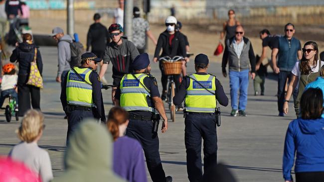 Victoria Police officers patrol St Kilda beach in Melbourne.