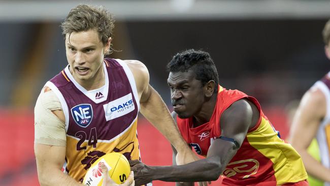 Former Redcliffe Tigers junior Liam Dawson shrugs a tackle playing for Brisbane Lions NEAFL side against Gold Coast.