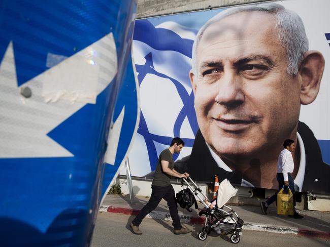 A man walks by an election campaign billboard showing Israel's Prime Minister Benjamin Netanyahu, the Likud party leader, in Tel Aviv, Israel, in April. Picture: AP