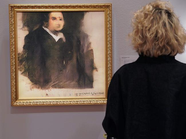 A woman looks at a work of art created by an algorithm by French collective named OBVIOUS which produces art using artificial intelligence, titled "Portrait of Edmond de Belamy" (estimate: $7,000-10,000) at Christie’s in New York on October 22, 2018. - The work of art will be included in the Prints & Multiples auction in New York October 23-25, 2018. (Photo by TIMOTHY A. CLARY / AFP) / RESTRICTED TO EDITORIAL USE - MANDATORY MENTION OF THE ARTIST UPON PUBLICATION - TO ILLUSTRATE THE EVENT AS SPECIFIED IN THE CAPTION