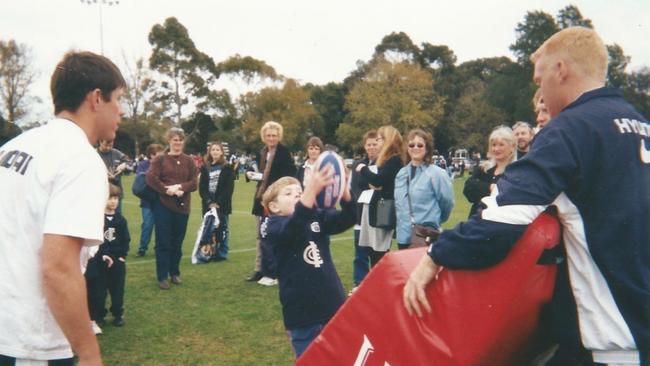 A youn Sam Docherty taking a mark in front of Carlton players Brett Ratten (left) and Lance Whitnall.