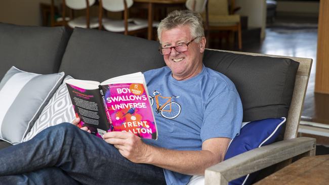 Patrick Condren puts his feet up at home as he reads award-winning novel Boy Swallows Universe, by The Australian’s Trent Dalton. Picture: Glenn Hunt