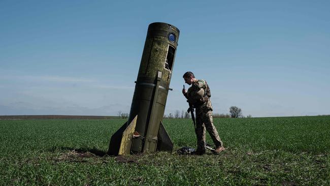 A Ukrainian serviceman looks at a Russian ballistic missile's booster stage that fell in a field in Bohodarove, eastern Ukraine. Picture: AFP