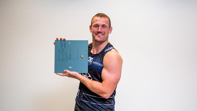 Cowboys player Coen Hess with his signed locker door which will go up for auction as part of the Cowboys Community Foundation's Christmas Auction.