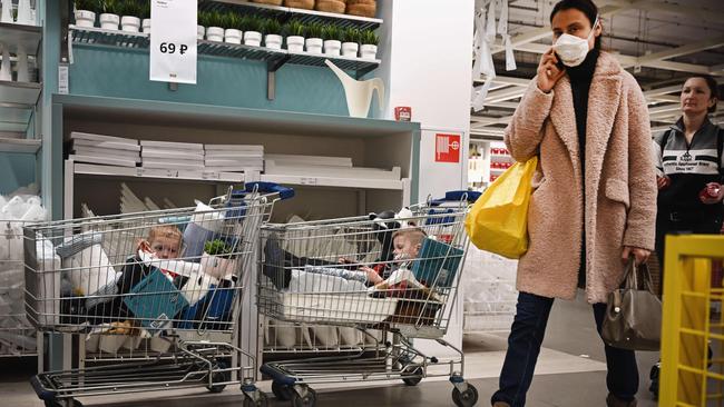 Children sit in a trolley while their parents shop in a store in Moscow on Monday. Picture: AFP