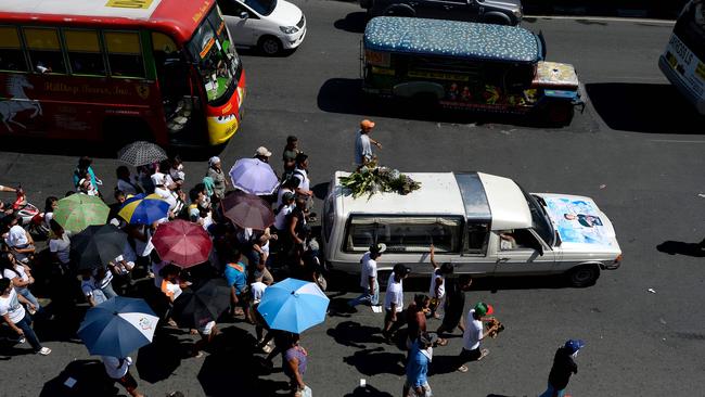 Relatives of Michael Siaron follow a hearse carrying his coffin during his burial ceremony at a cemetery in Manila. Picture: Noel Celis/AFP