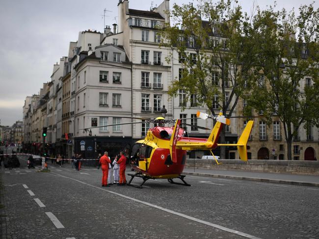 Emergency personel stand near an air ambulance helicopter on the Pont Marie near Paris prefecture de police (police headquarters). Picture: AFP