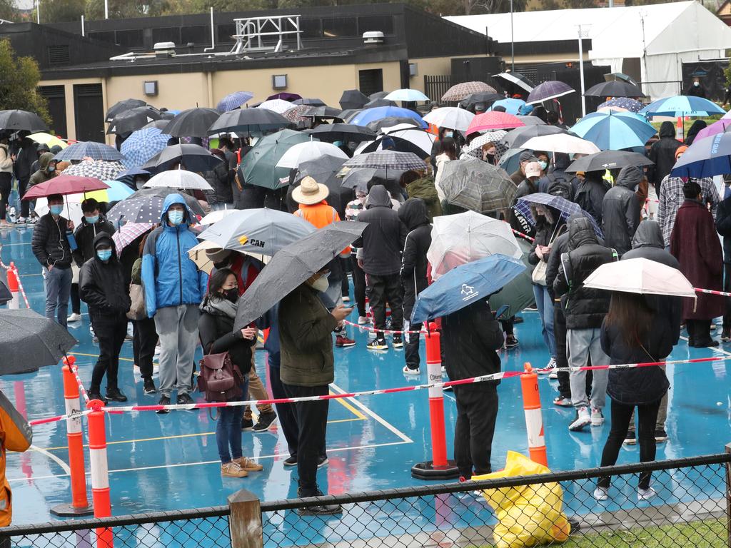 People line up in the rain at the vaccination hub in St Kilda. Picture: David Crosling