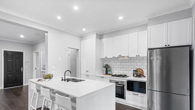 An island elevates the all-white kitchen.