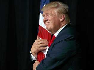 Republican presidential candidate Donald Trump hugs an American flag as he arrives to speak to a campaign rally, Monday, Oct. 24, 2016, in Tampa, Fla. (AP Photo/ Evan Vucci). Picture: Evan Vucci