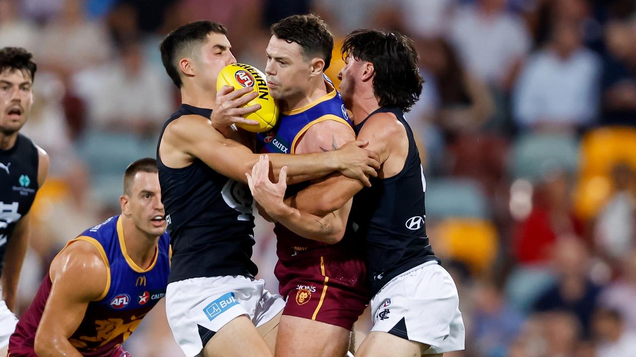 Lachie Neale of the Lions is tackled by George Hewett and Oliver Hollands of the Blues. Picture: Dylan Burns/AFL Photos via Getty Images