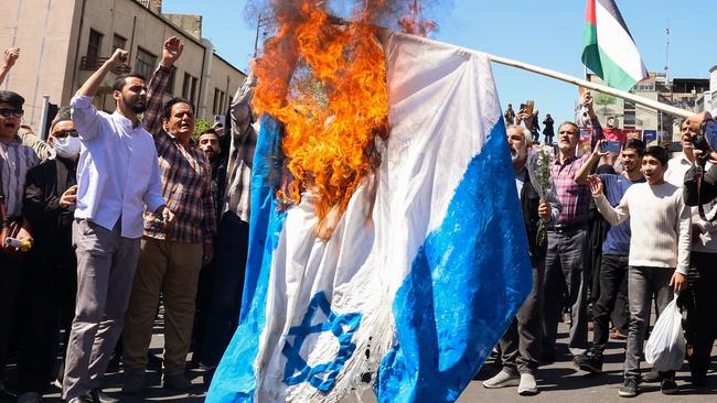 An Israeli flag is set alight during the funeral in Tehran for seven Islamic Revolutionary Guard Corps members killed in a strike in Syria. Picture: AFP