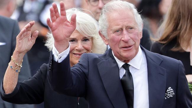 King Charles III and Camilla, Queen Consort, wave after viewing floral tributes to the late Queen Elizabeth II outside Buckingham Palace. Picture: Getty Images