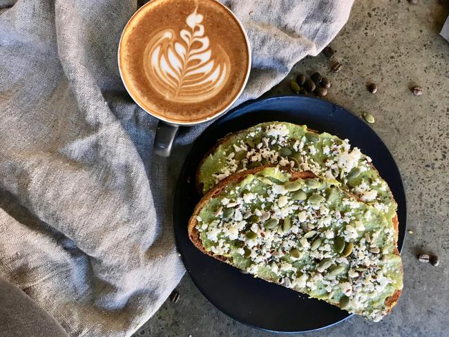 The Bikesmith & Espresso Bar’s flat white coffee with smashed avocado and fetta on toast. Picture: Jenifer Jagielski