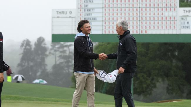 Amateur Harrison Crowe shakes hands with Larry Mize. Picture: AFP