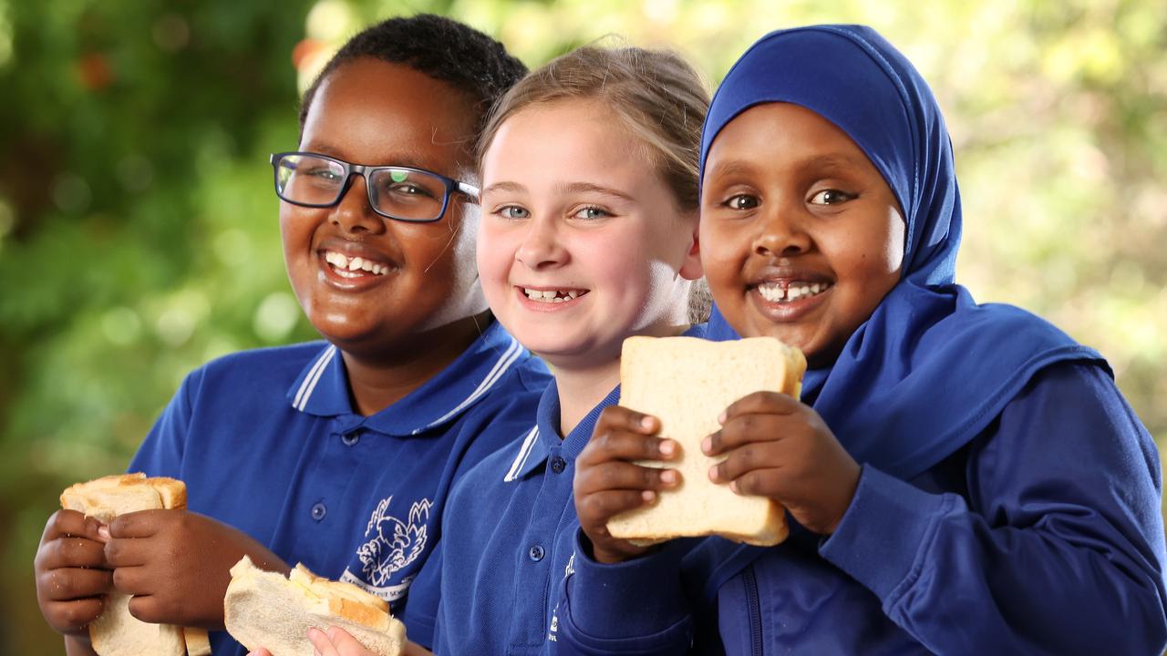 Abdirisaq, 8, Olivia, 8, and Ubah, 5, enjoying some of the donated food for kids at Richlands East State School, Inala. Picture: Liam Kidston