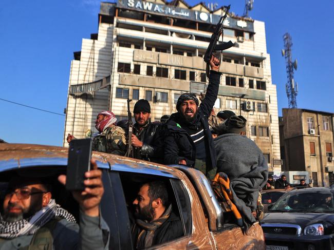 Syrian rebel fighters celebrate near the Clock Tower in Homs. Pictuee: Aaref Watad/AFP