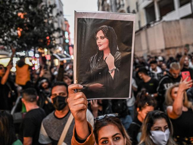 -- AFP PICTURES OF THE YEAR 2022 --  A protester holds a portrait of Mahsa Amini  during a demonstration in support of Amini, a young Iranian woman who died after being arrested in Tehran by the Islamic Republic's morality police, on Istiklal avenue in Istanbul on September 20, 2022. - Amini, 22, was on a visit with her family to the Iranian capital when she was detained on September 13 by the police unit responsible for enforcing Iran's strict dress code for women, including the wearing of the headscarf in public. She was declared dead on September 16 by state television after having spent three days in a coma. (Photo by Ozan KOSE / AFP) / AFP PICTURES OF THE YEAR 2022