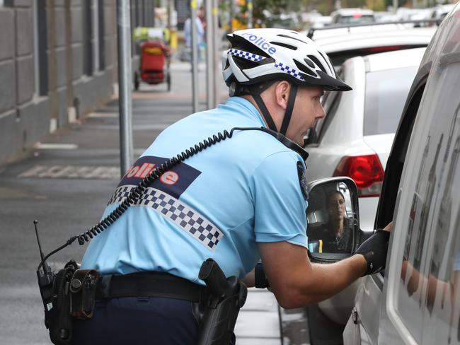 Senior Constable Uwe Stolzenberg talks to a driver after she was caught on her mobile phone. Picture: David Crosling