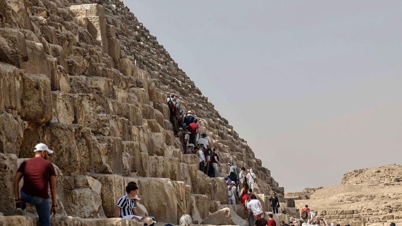 Tourists visit the Great Pyramid of Khufu (Cheops) at the Giza Pyramids necropolis on the southwestern outskirts of Cairo, on March 2, 2023. (Photo by Khaled DESOUKI / AFP)