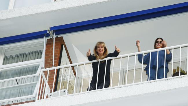 Left: Building supervisor and resident Gina Auchinachie joins the singing from her balcony. Picture: John Appleyard