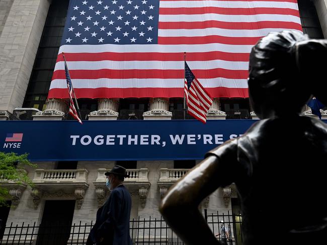 (FILES) In this file photo a man passes the building before the opening bell at the New York Stock Exchange (NYSE) on May 26, 2020 on Wall Street in New York City. - Wall Street stocks dipped in early trading June 1, 2020 as markets digested a weekend of civil rights protest across the US as the country reopened from coronavirus shutdowns. About five minutes into trading, the Dow Jones Industrial Average stood at 25,224.61, down 0.6 percent.The broad-based S&P 500 shed 0.4 percent to 3,032.19, while the tech-rich Nasdaq Composite Index declined 0.2 percent to 9,467.69. (Photo by Johannes EISELE / AFP)