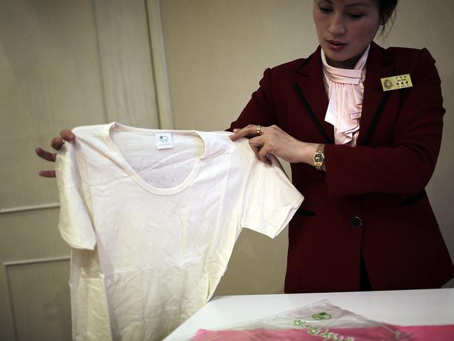 A saleswoman shows off a locally produced t-shirt made out of hemp in Pyongyang on January 9. Hemp is grown with official sanction in North Korea, and is used to make cooking oil and military uniforms. Picture: AP/Wong Maye-E