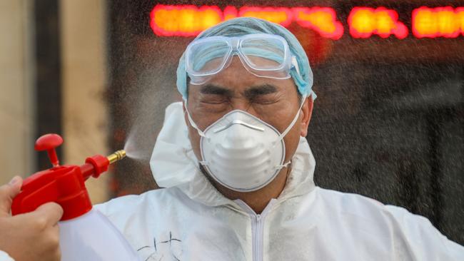 A doctor being disinfected by his colleague at a quarantine zone in Wuhan, the epicentre of the coronavirus outbreak, in China's central Hubei province, in February. Picture: AFP