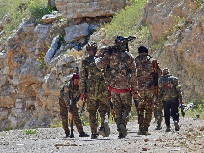 Fighters with the Syrian Democratic Forces (SDF) patrol near  the village of Baghouz in the countryside of the eastern Syrian province of Deir Ezzor on March 20, 2019. (Photo by GIUSEPPE CACACE / AFP)