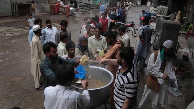 People line up to receive free food in Lahore, Pakistan, this month. Picture: Shutterstock