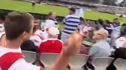 Screen grabs of an NRL  Dragons supporter who purchased a meat pie and threw it at a Bulldog's  supporter at the match. , , Source - Facebook: https://www.facebook.com/watch/?v=3915252775469020, ,