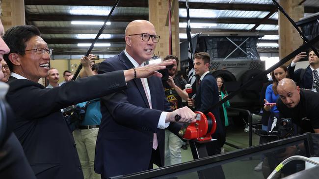 Mr Dutton tries his hand at a winch at an off-road equipment store in Myaree in the target seat of Tangney on Friday. Picture: Adam Head / NewsWire