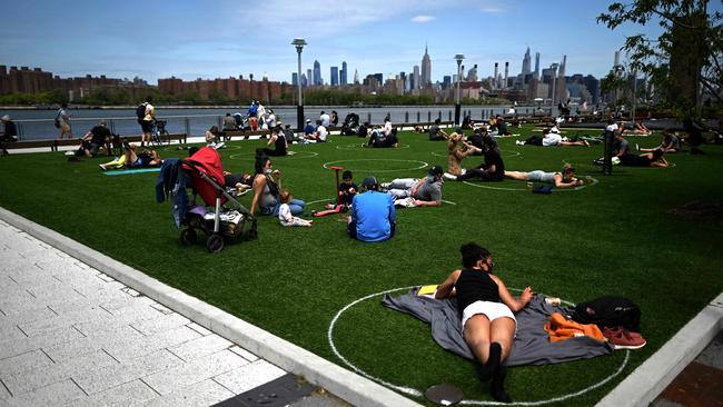 People are seen practising social distancing in white circles in Domino Park, during the COVID-19 pandemic in New York City. Picture: AFP