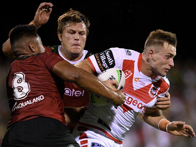 Jacob Host of the Dragons is tackled by Junior Tatola (left) and Liam Knight of the Rabbitohs during the Charity Shield. Picture: AAP Image/Dan Himbrechts