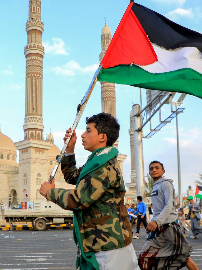 A Yemeni youth waves a Palestinian flag during a march in solidarity with the people of Gaza, in the Huthi-controlled capital Sanaa. Picture: AFP.