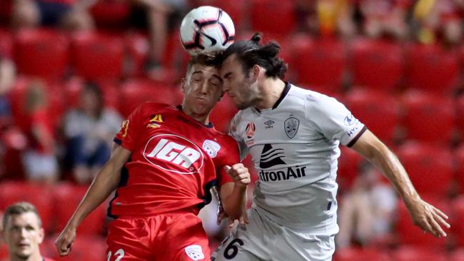 Adelaide United’s Carlo Armiento heads the ball clear of Brisbane Roar’s Nicholas D'Agostino in February. (AAP Image/Kelly Barnes) 