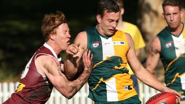 Matthew Perry kicks under pressure from Josh Turner. Picture: Hamish Blair