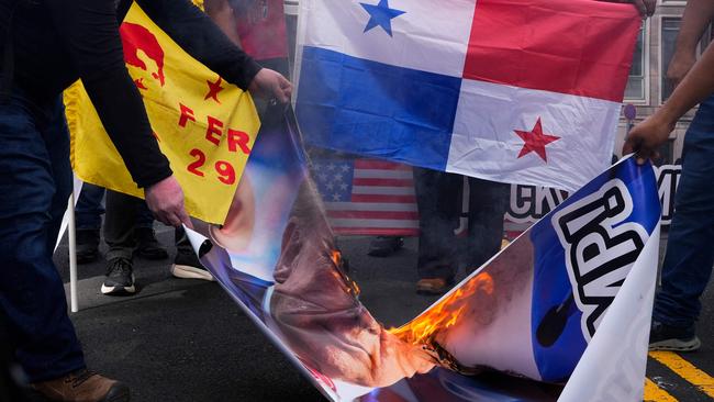 Demonstrators burn a banner with the image of US President-elect Donald Trump during a protest outside the US embassy in Panama City. Picture: Arnulfo Franco/AFP