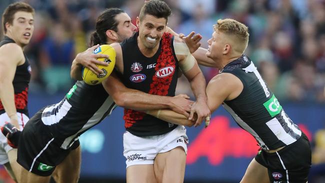 Brodie Grundy and Adam Treloar tackle Essendon's David Myers. Picture: Alex Coppel.